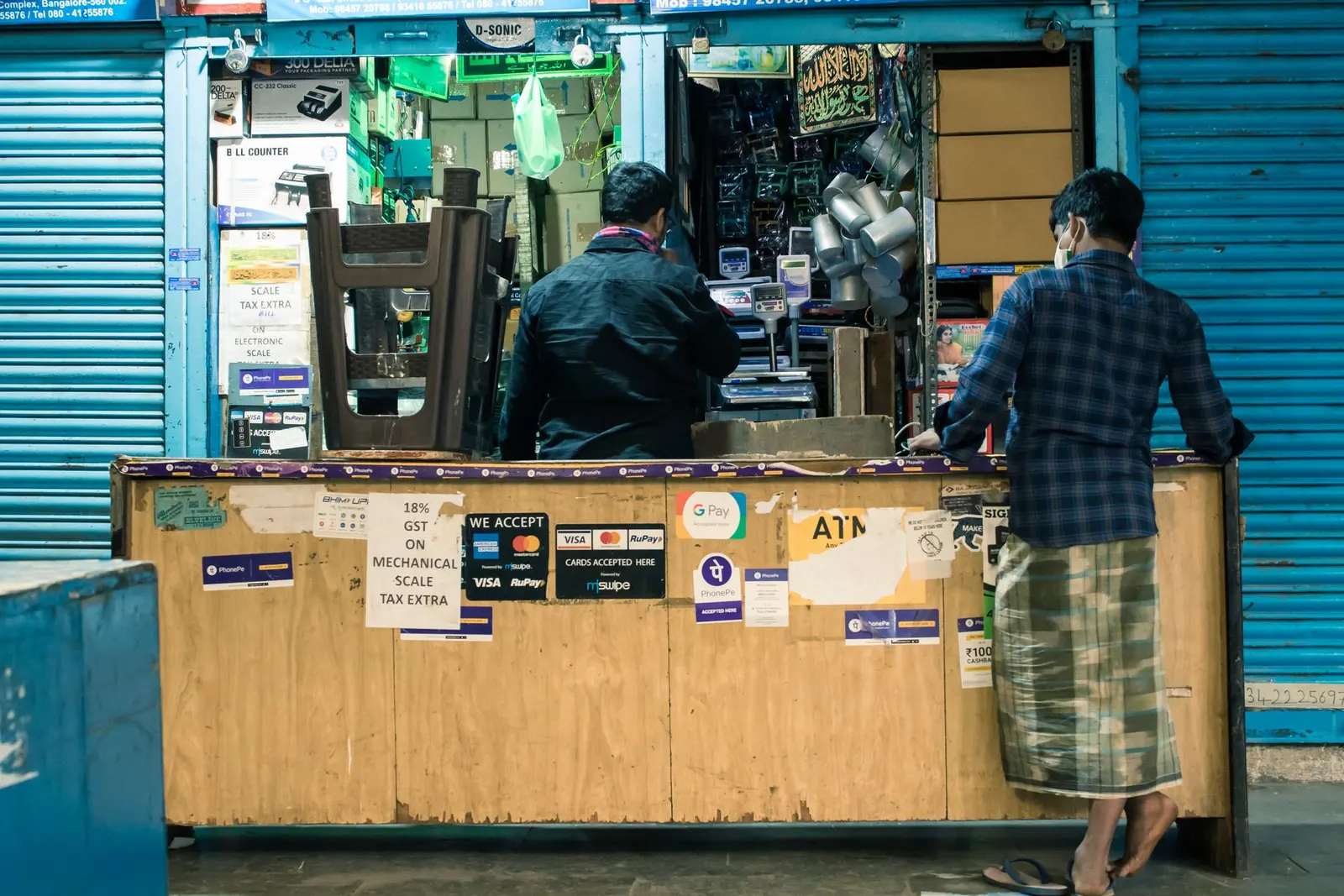 Shopkeeper and customer at a billing counter in a Bengaluru market